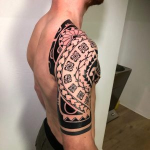 Maori-inspiriertes Tattoo auf Schulter und oberem Rücken mit geometrischen und traditionellen Mustern